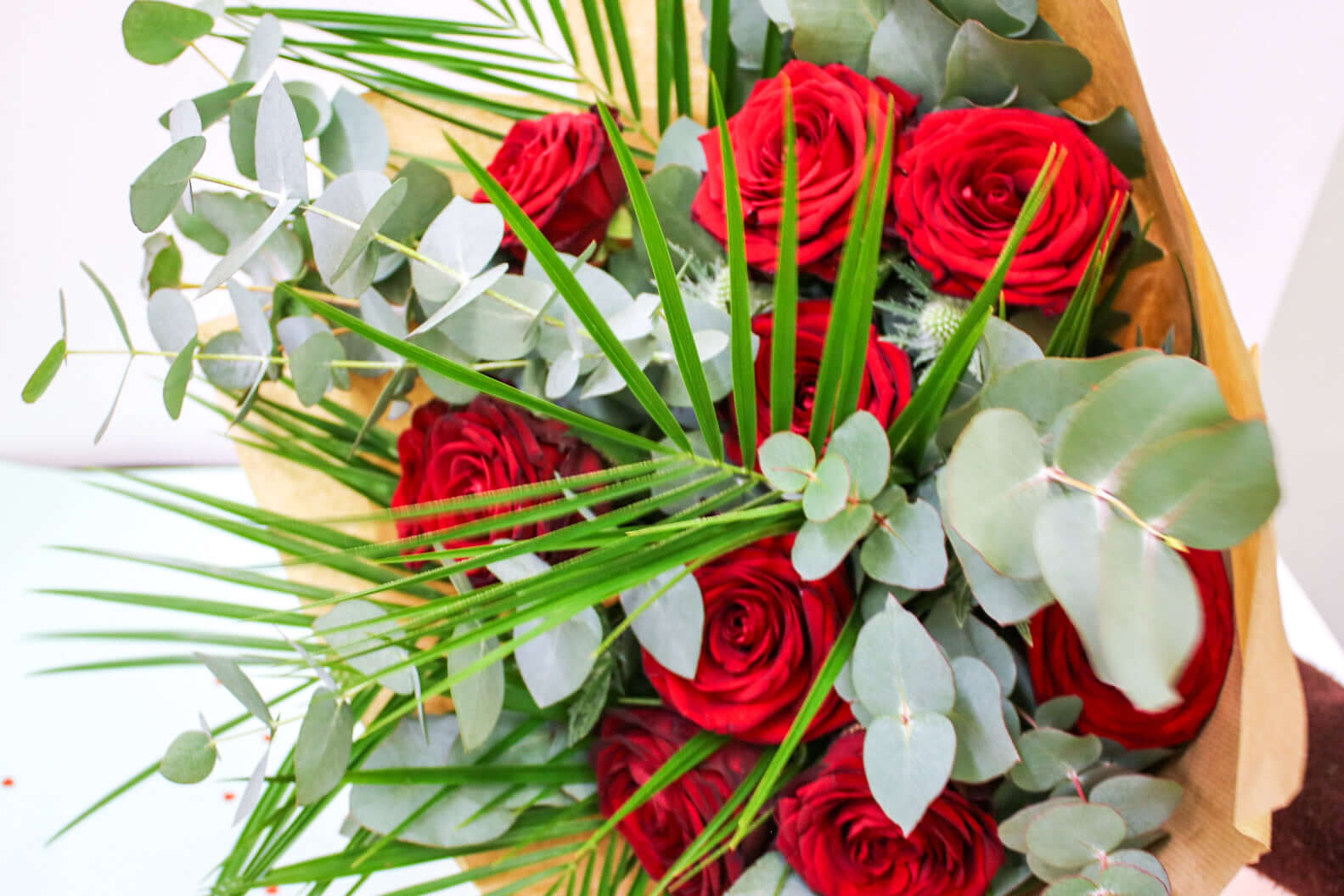 A striking combination of bold red roses and airy eucalyptus leaves, capturing romance and elegance.