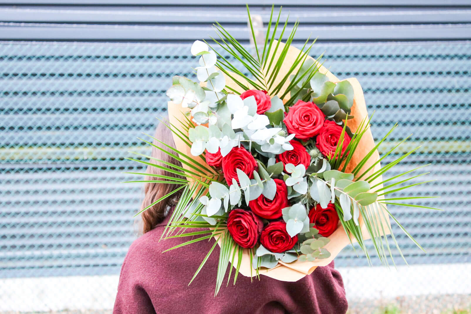 A lush bouquet of velvety red roses and silver-toned eucalyptus, perfect for expressing love