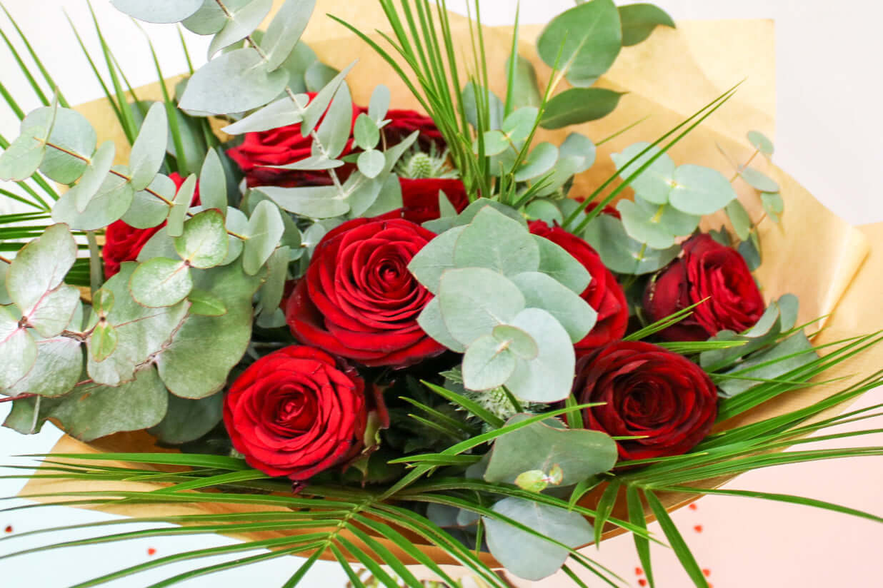 Arrangement of deep red roses and fresh eucalyptus
