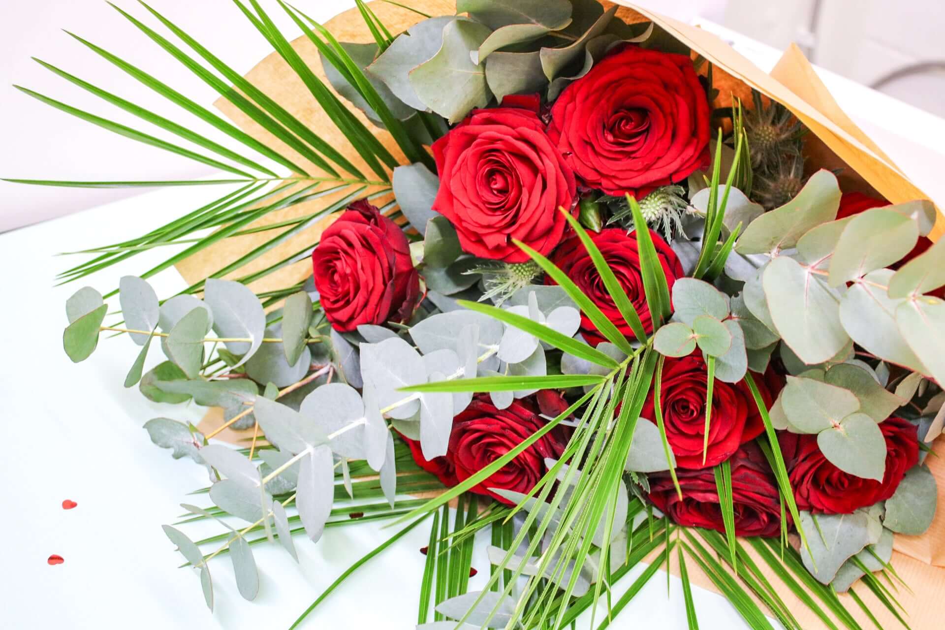 Bouquet of fresh red roses paired with fragrant eucalyptus for a timeless and elegant arrangement.