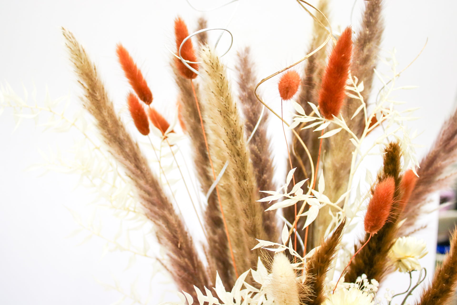 Boho pampas bouquet with a combination of dried pampas grass, wildflowers, and foliage, perfect for rustic wedding decorations or home styling.