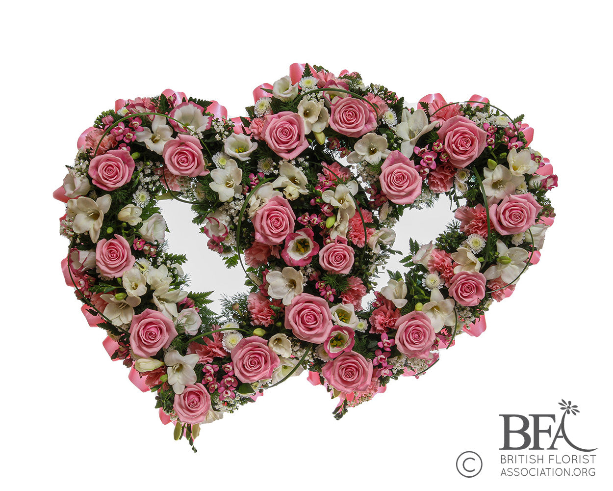 A double open heart tribute made with a variety of mixed flowers and pink roses, creating a loving tribute.