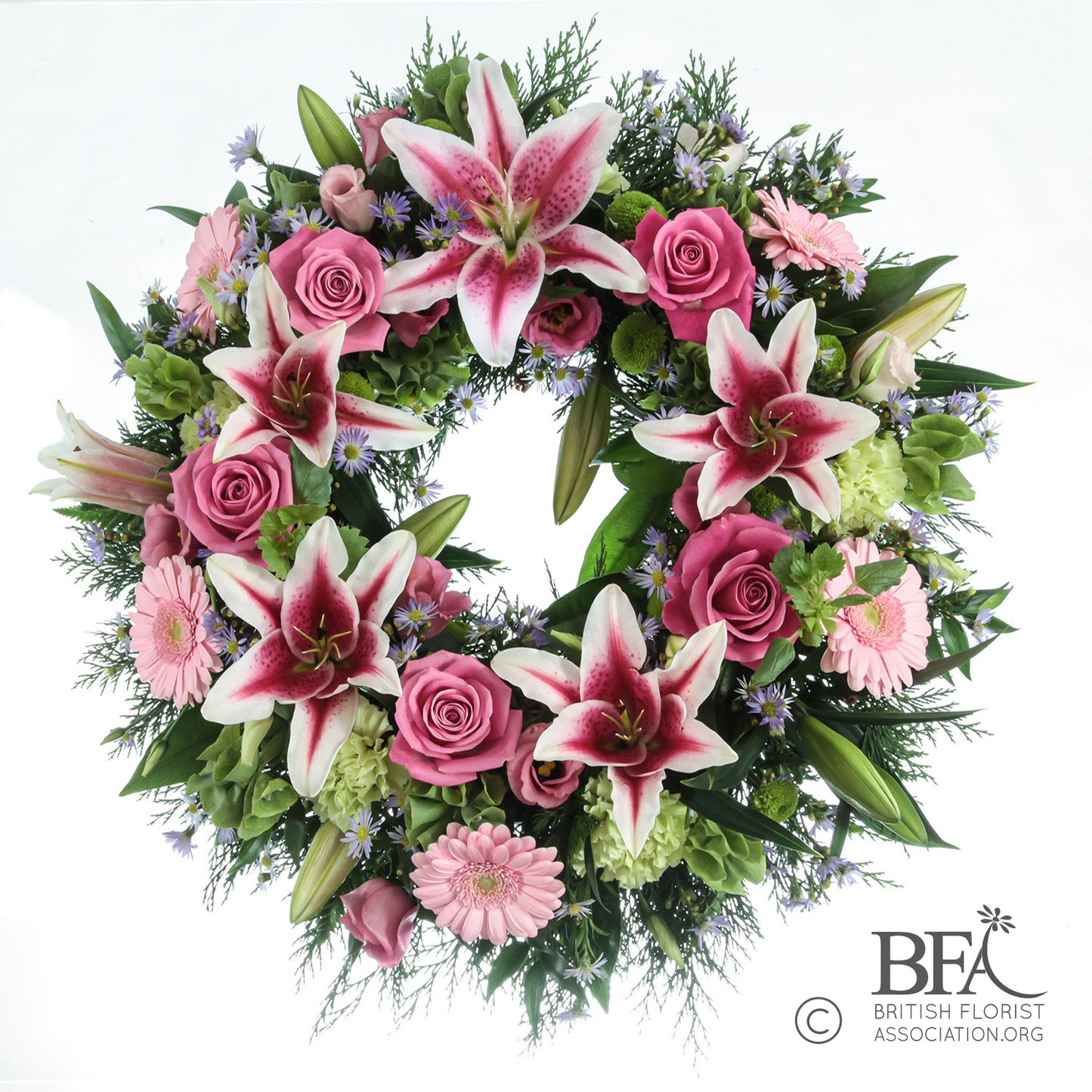 Elegant funeral wreath featuring white lilies and soft pink roses, arranged in Stevenage with care and seasonal foliage.
