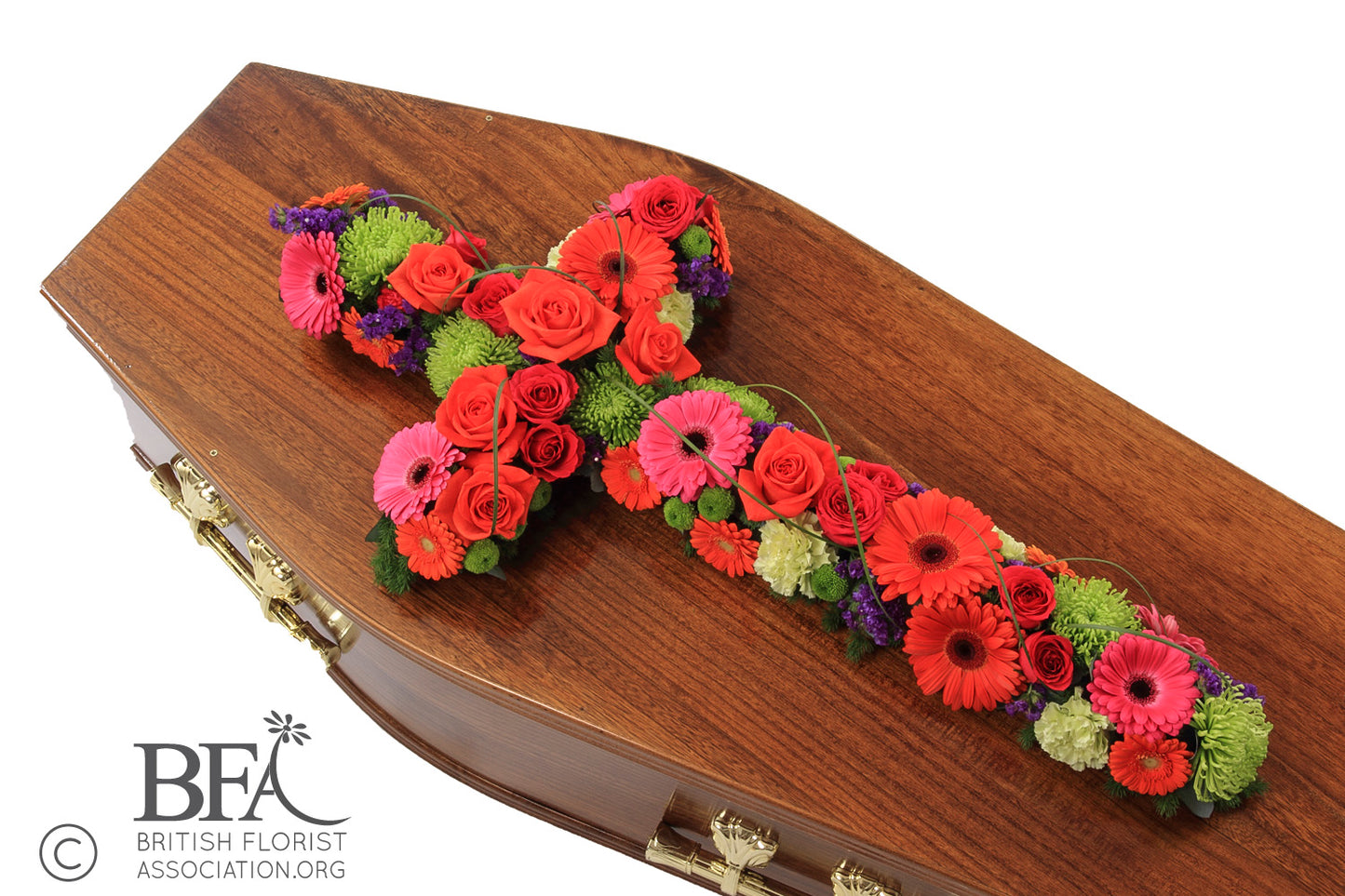 A hand-crafted open cross tribute, featuring gerberas, roses, chrysanthemums, and carnations in vibrant colors.