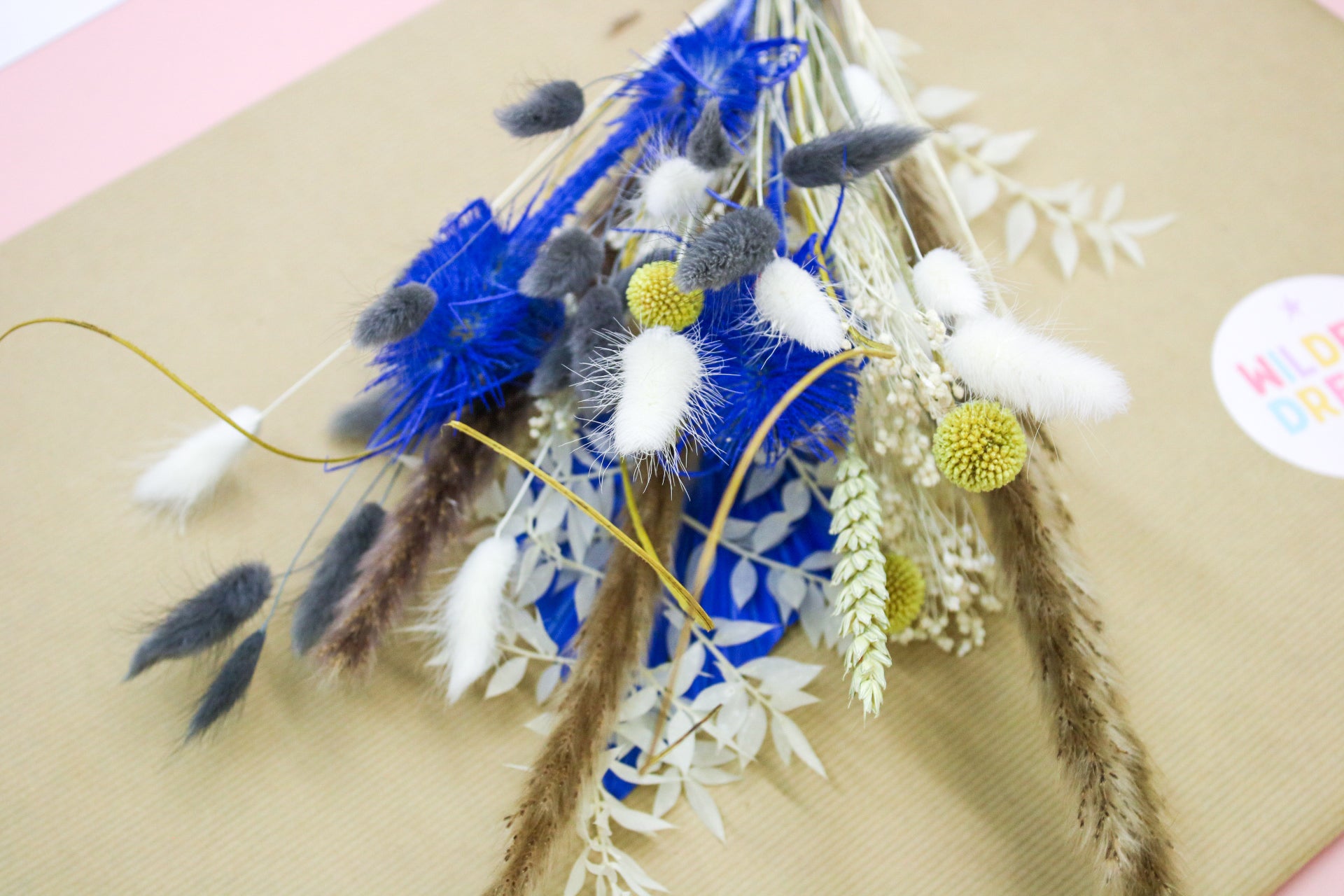 Elegant yellow and blue dried flower bouquet arranged in a vase, featuring pampas grass and dried florals. Ideal for home decor, weddings, and events, with delivery available.