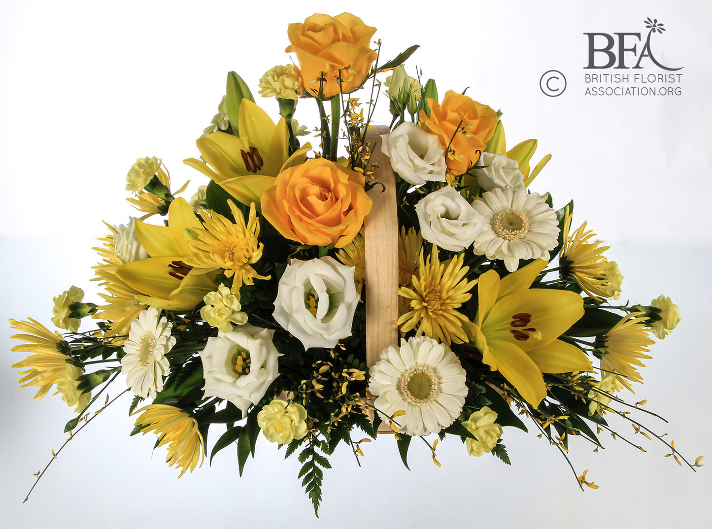 A vibrant basket arrangement of yellow roses, lilies, and cream gerbera, offering a lively tribute.