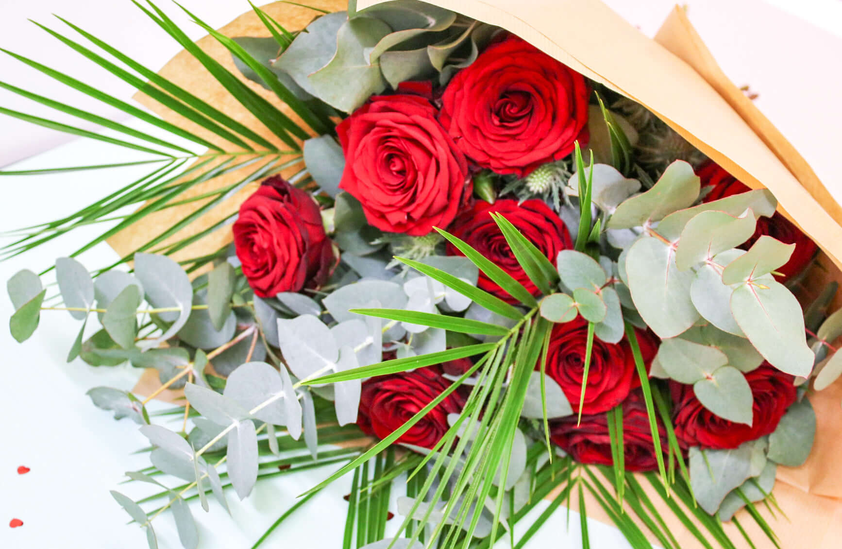 A romantic bouquet of rich red roses accented with soft eucalyptus greenery,