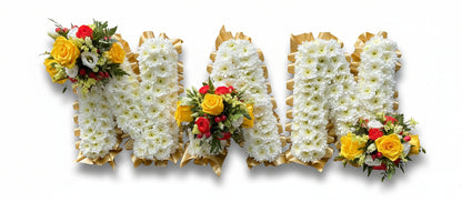 Floral arrangement spelling out 'MOM' with white, yellow, and red flowers on a white background