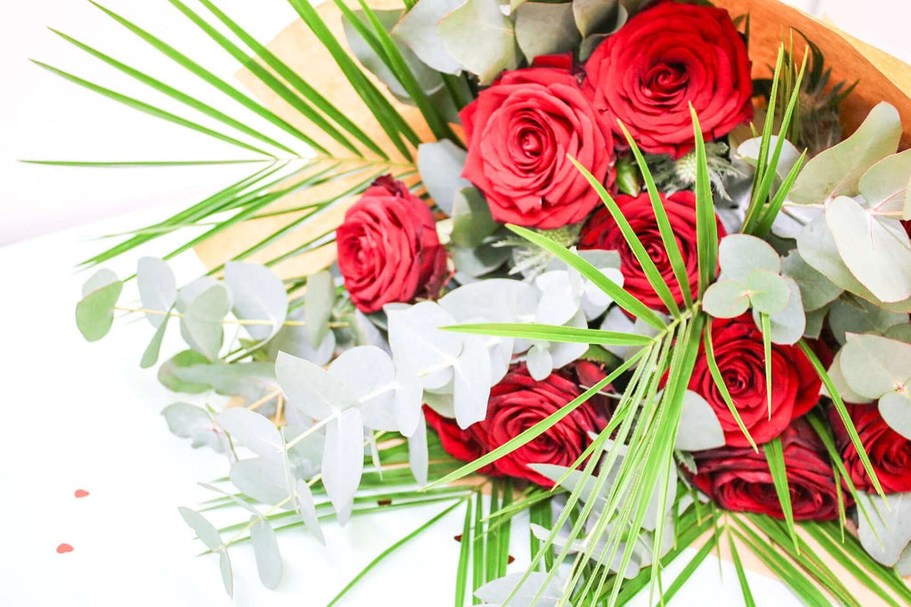 Freshly picked red roses with delicate eucalyptus sprigs, arranged to enhance their natural beauty