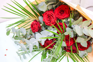 Bouquet of fresh red roses paired with fragrant eucalyptus for a timeless and elegant arrangement.