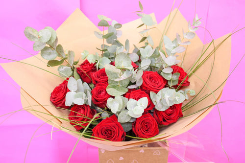 Close-up of 12 luxury red roses with velvety petals and deep romantic tones