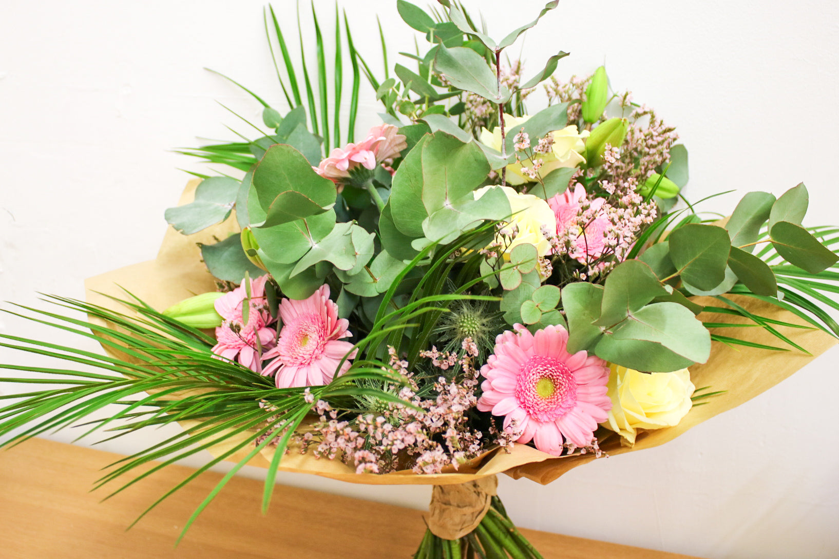 Pink and white floral bouquet with gerberas and thistle styled on a table – romantic gift idea for Valentine's Day

