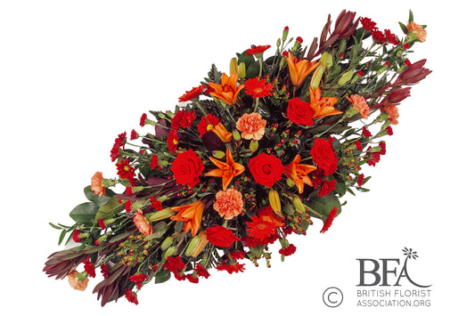  A luxurious double-ended spray made with high-quality lilies, roses, carnations, and seasonal foliage.
