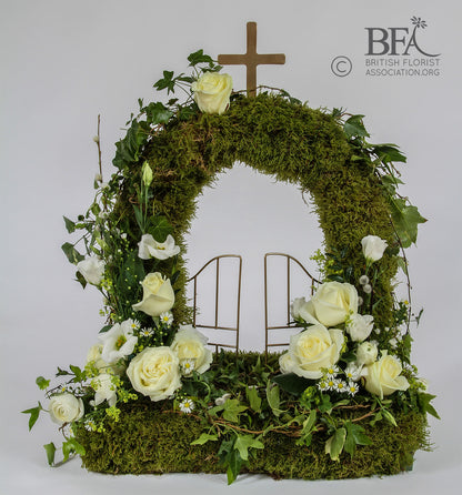 Elegant moss gates of heaven tribute, created with fresh flowers and moss in a beautiful design.