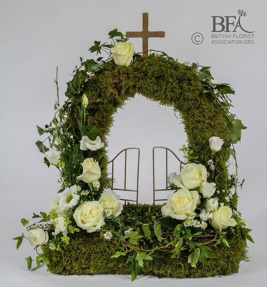 Elegant moss gates of heaven tribute, created with fresh flowers and moss in a beautiful design.