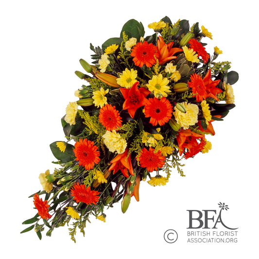 A vibrant orange one-side tribute spray featuring bright orange roses, gerberas, and carnations, symbolizing warmth and love in remembrance.