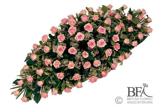 A soft pink rose and gypsophila spray, an elegant and delicate tribute for a loved one.