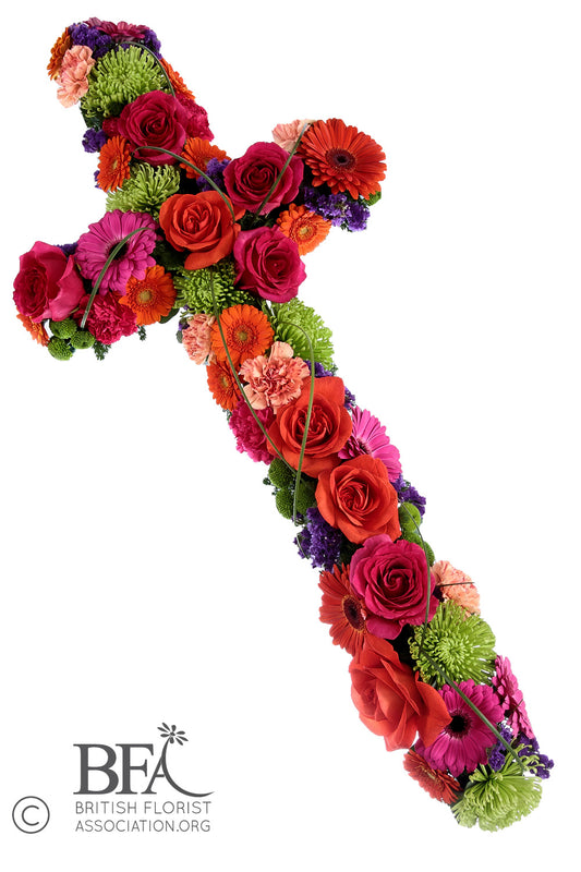 Vibrant floral cross tribute with bold cerise, orange, and purple flowers, handcrafted in Stevenage for a colourful and respectful farewell.