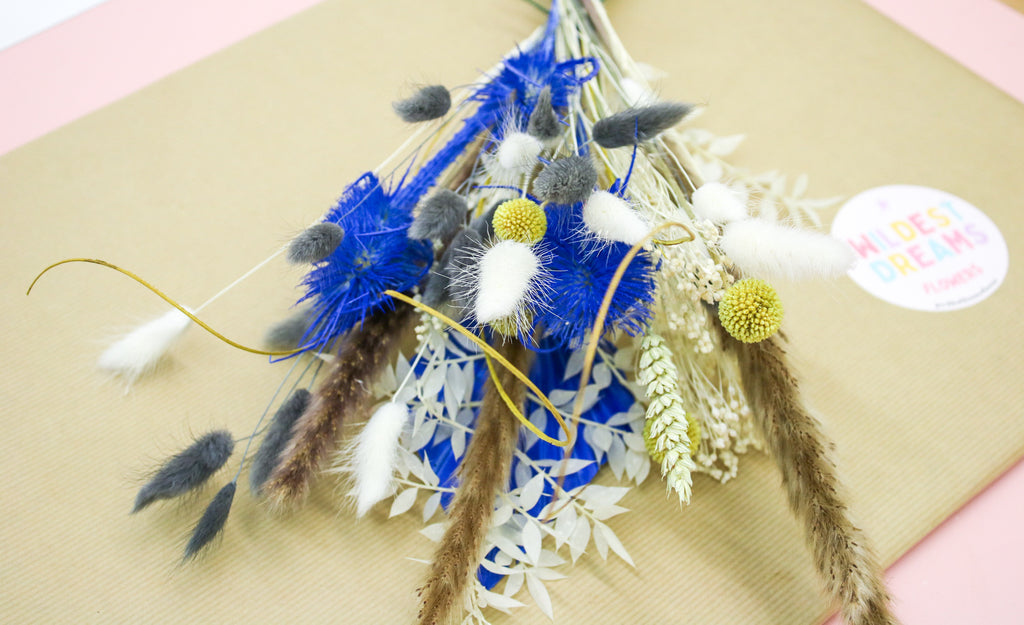 A vibrant yellow and blue dried flower bouquet featuring a mix of pampas grass and wildflowers, perfect for adding a pop of colour to any decor. Ideal for weddings, home decor, and as a thoughtful gift.